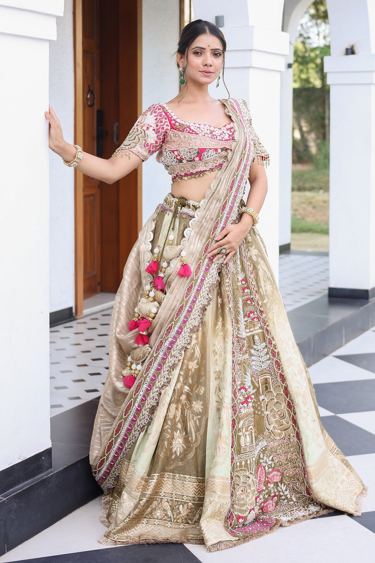 The Olive Green Shaded Brocade Silk Woven Lehenga Ensemble with Jharokha Embroidered Sweetheart Blouse and Attached Organza Dupatta