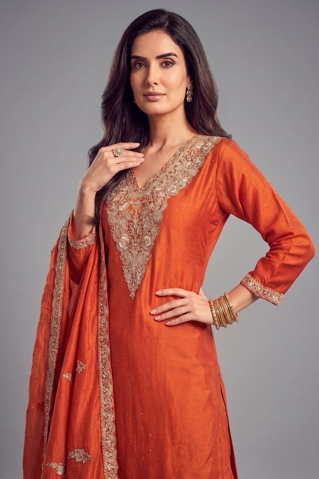 Close up of ivory and silver floral thread embroidery on orange art silk suit kurta