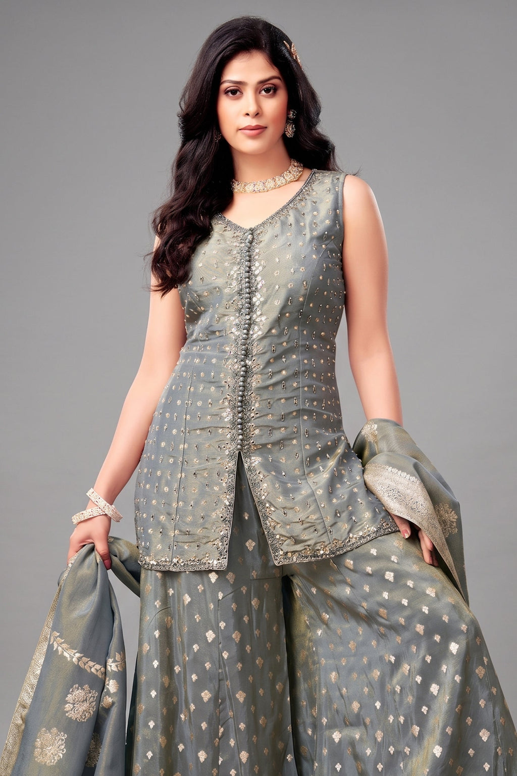 Woman wearing a traditional outfit with a gray top and skirt on a gray background